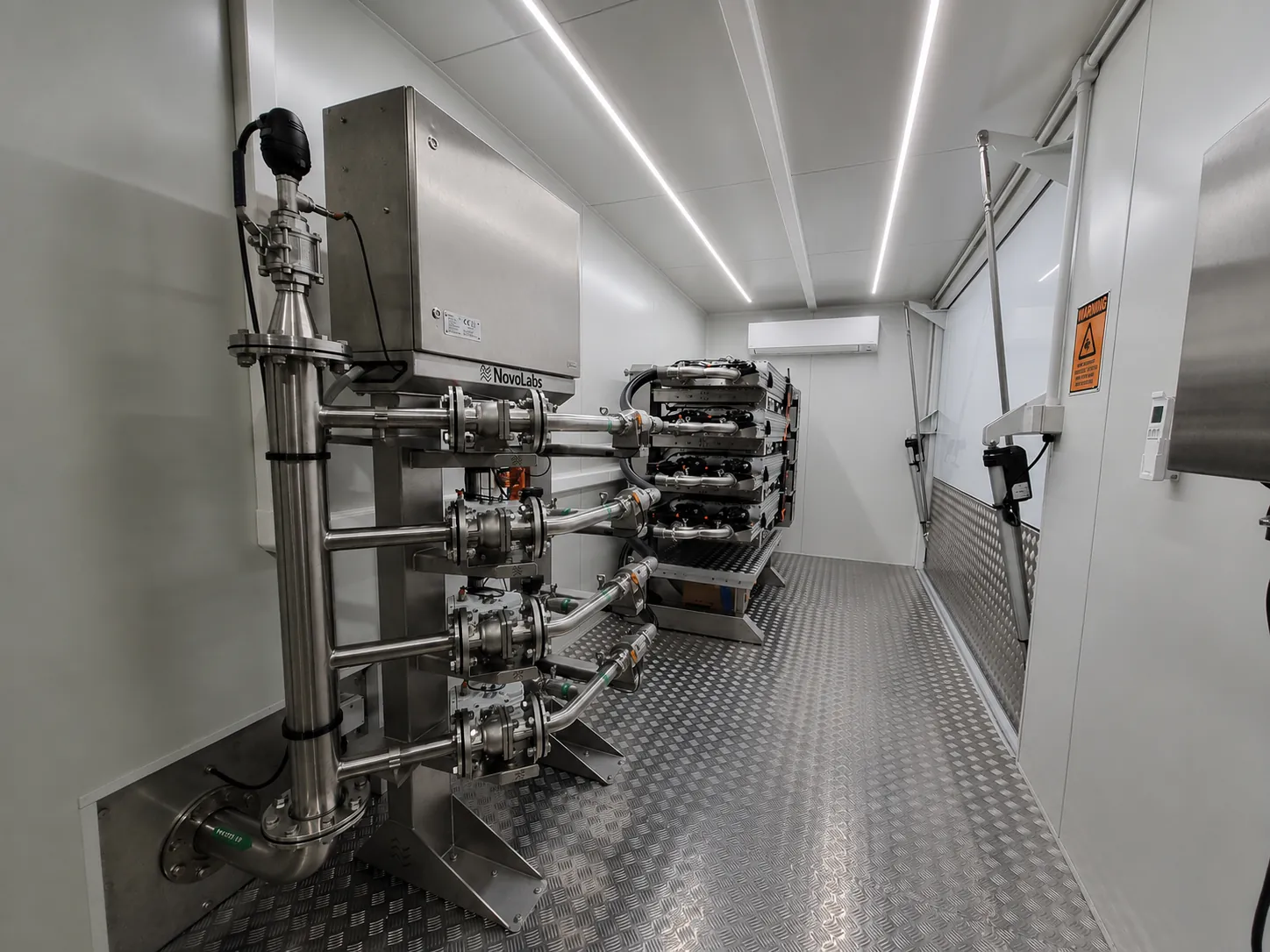Inside a container, a stainless steel manifold connects to a single stack of ultraviolet disinfection modules