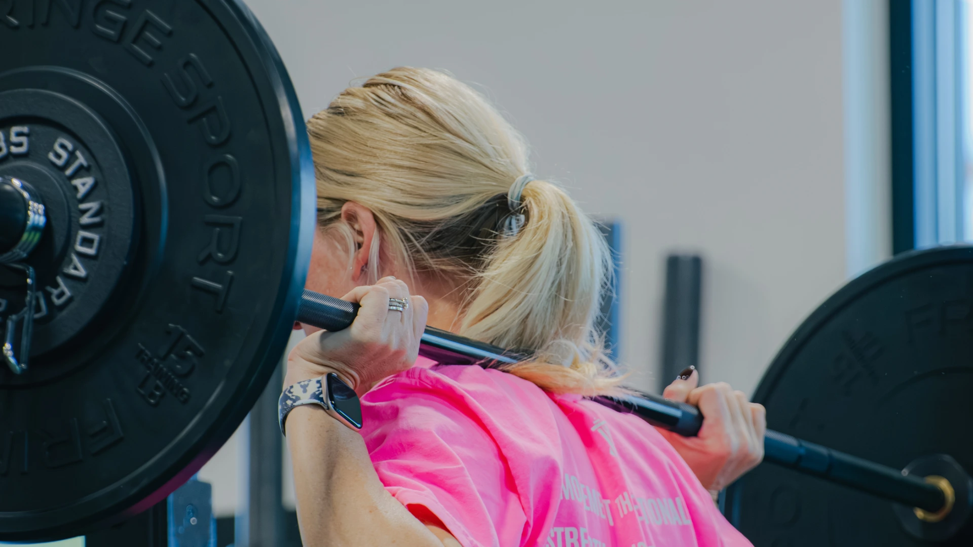 Woman performing a barbell back squat at VICTRESS MVMT