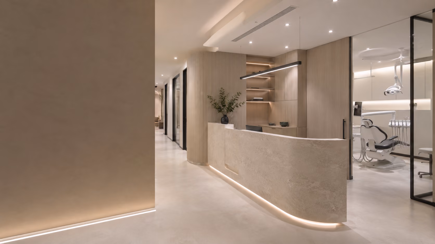 Modern dental clinic reception with curved desk, plant, and treatment rooms with dental chair.