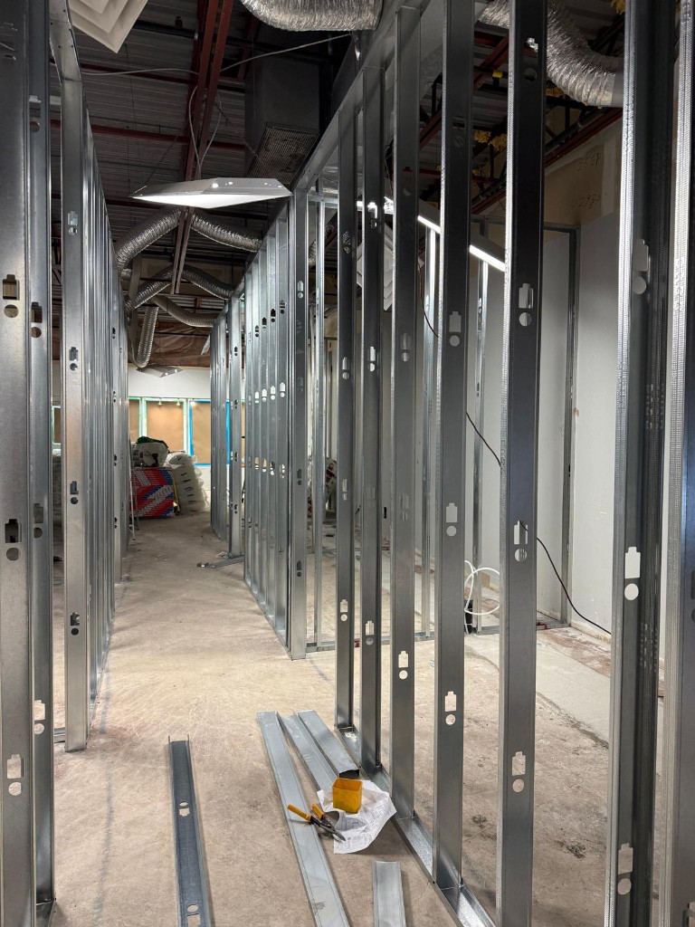 Steel stud framing for exam rooms along a corridor in the medical clinic conversion