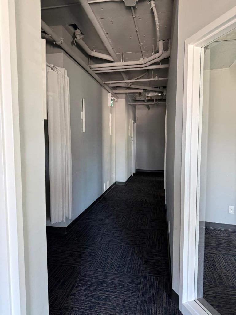 Carpeted corridor with open ceiling in a North York clinic fit-out