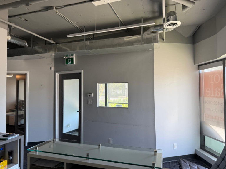 Office room with glass-panel door and exposed ceiling in a North York clinic fit-out
