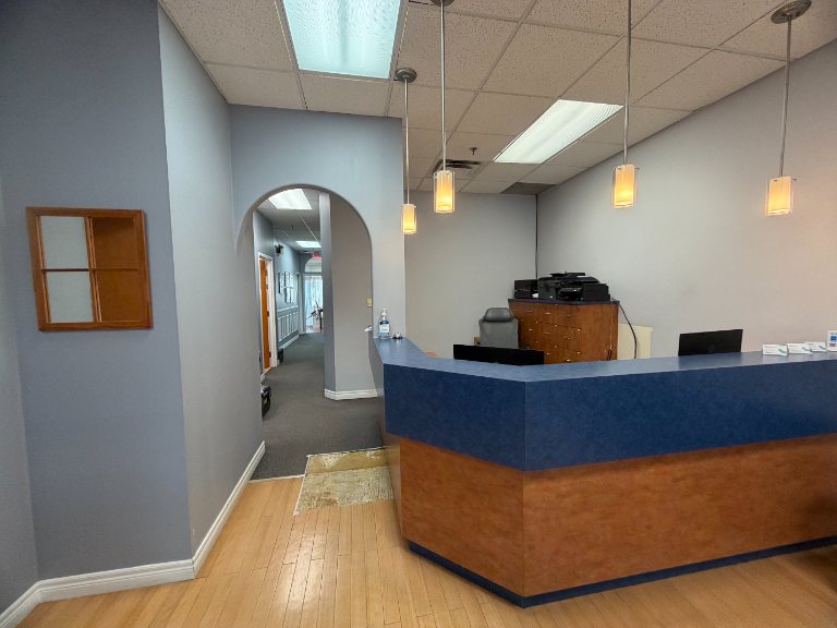 Reception counter with blue and wood finish in a Mississauga clinic during renovation