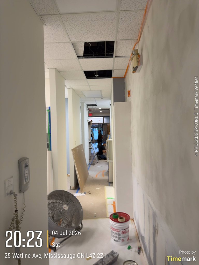 Clinic corridor with ceiling opened and walls patched during renovation in Mississauga