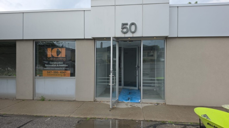 Entrance of a Scarborough commercial facility with an ICI Contracting sign in the window