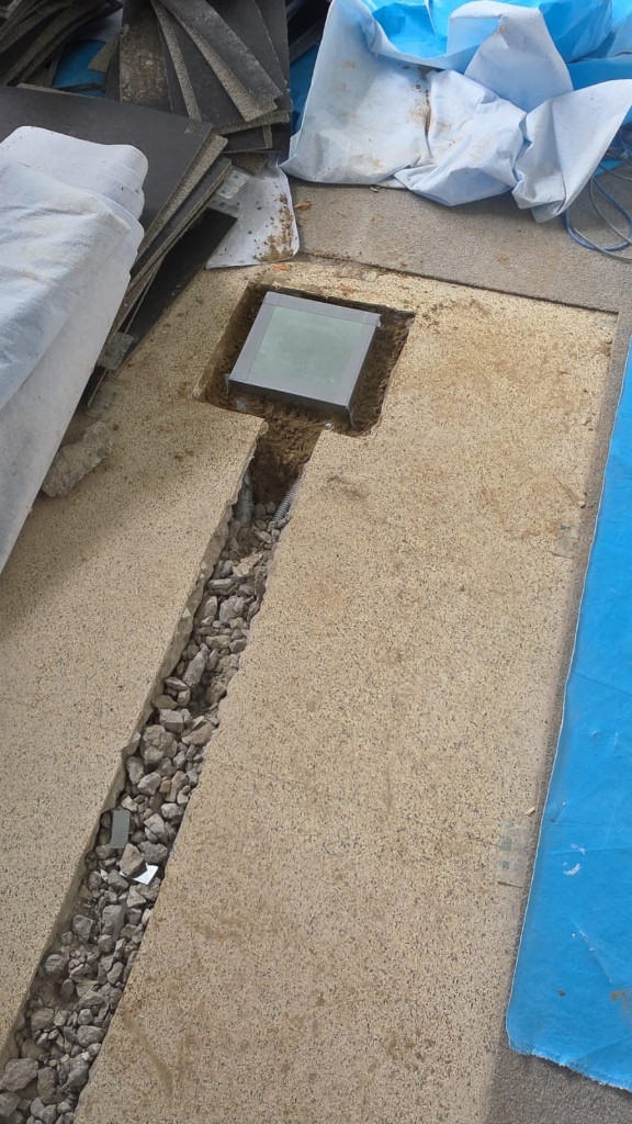 New floor drain and gravel-filled trench in the concrete slab at a Scarborough facility