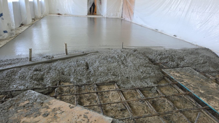 Fresh concrete placed over rebar mesh for a new floor slab inside a Scarborough facility