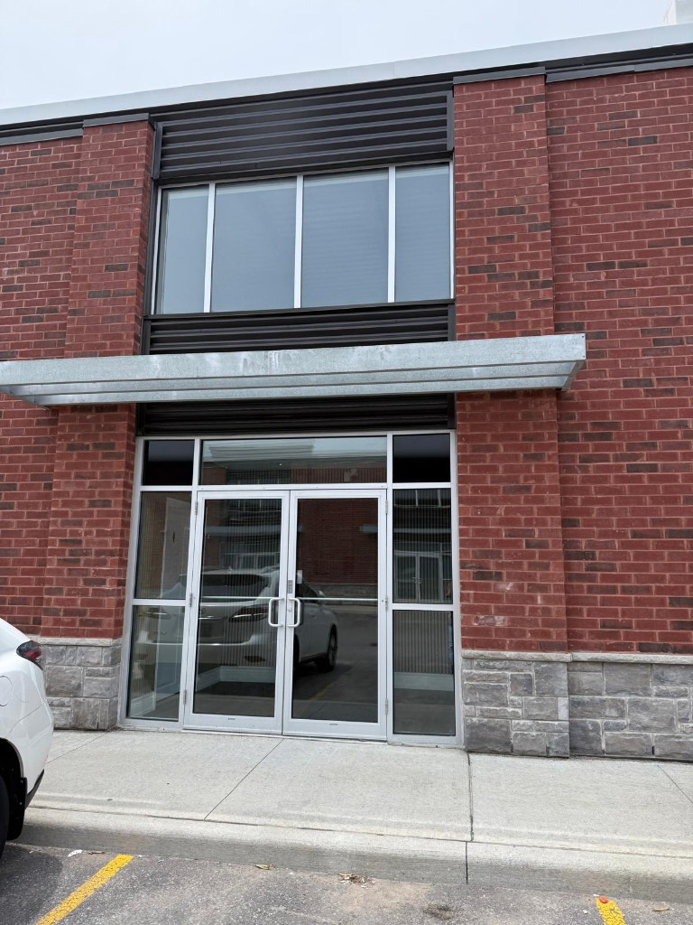 Brick storefront with glass entry doors and a metal canopy at an Oshawa commercial unit