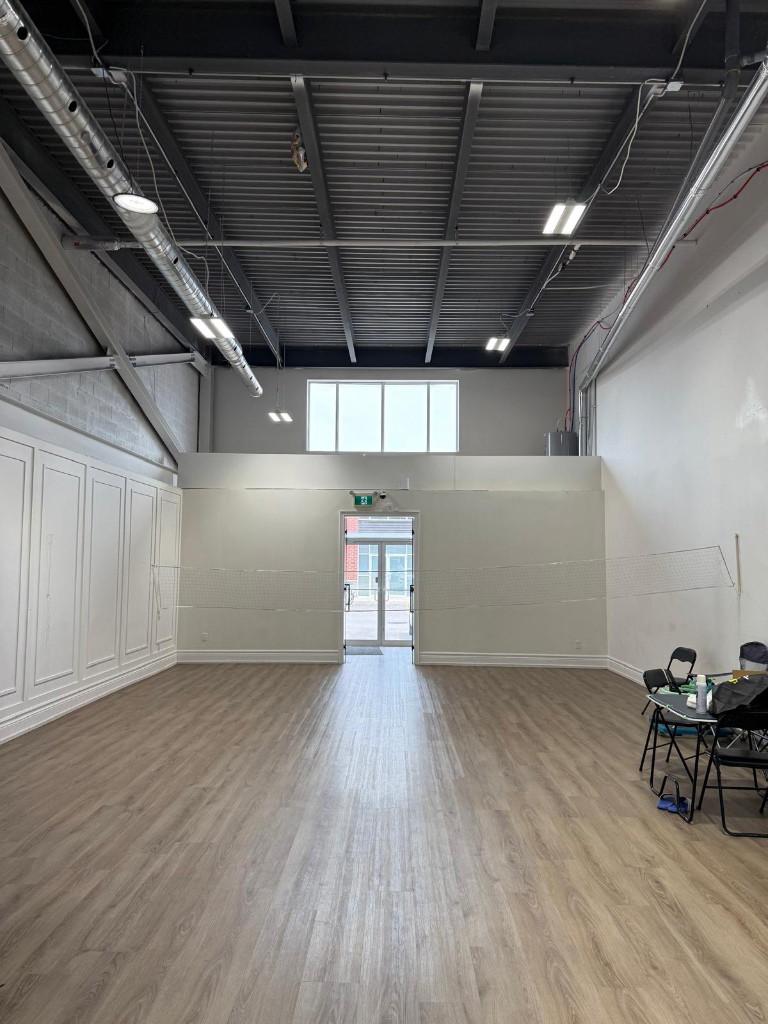 Open commercial unit interior with plank flooring and panelled walls in Oshawa