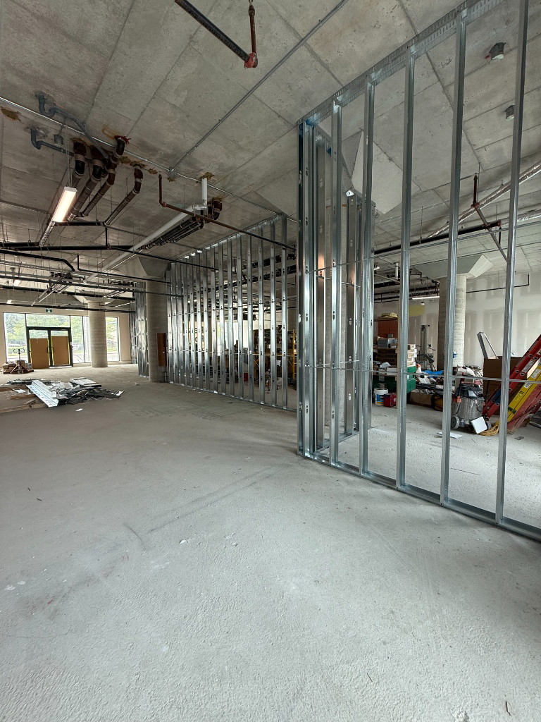 Steel stud partition framing under an exposed concrete ceiling in a Scarborough clinic
