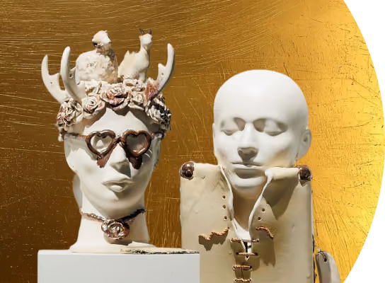 Two white sculpted busts against a gold textured background, one with heart-shaped glasses and antler adornment.