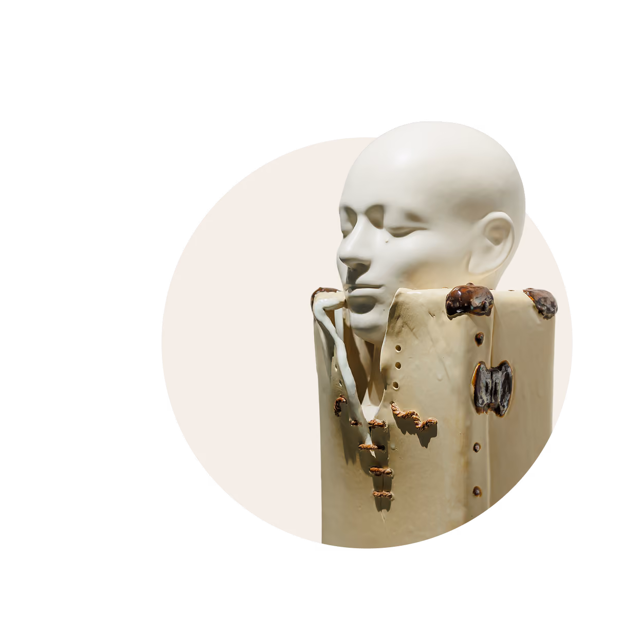 Modern sculpture of a smooth, bald human head resting on a rectangular base with textured details.