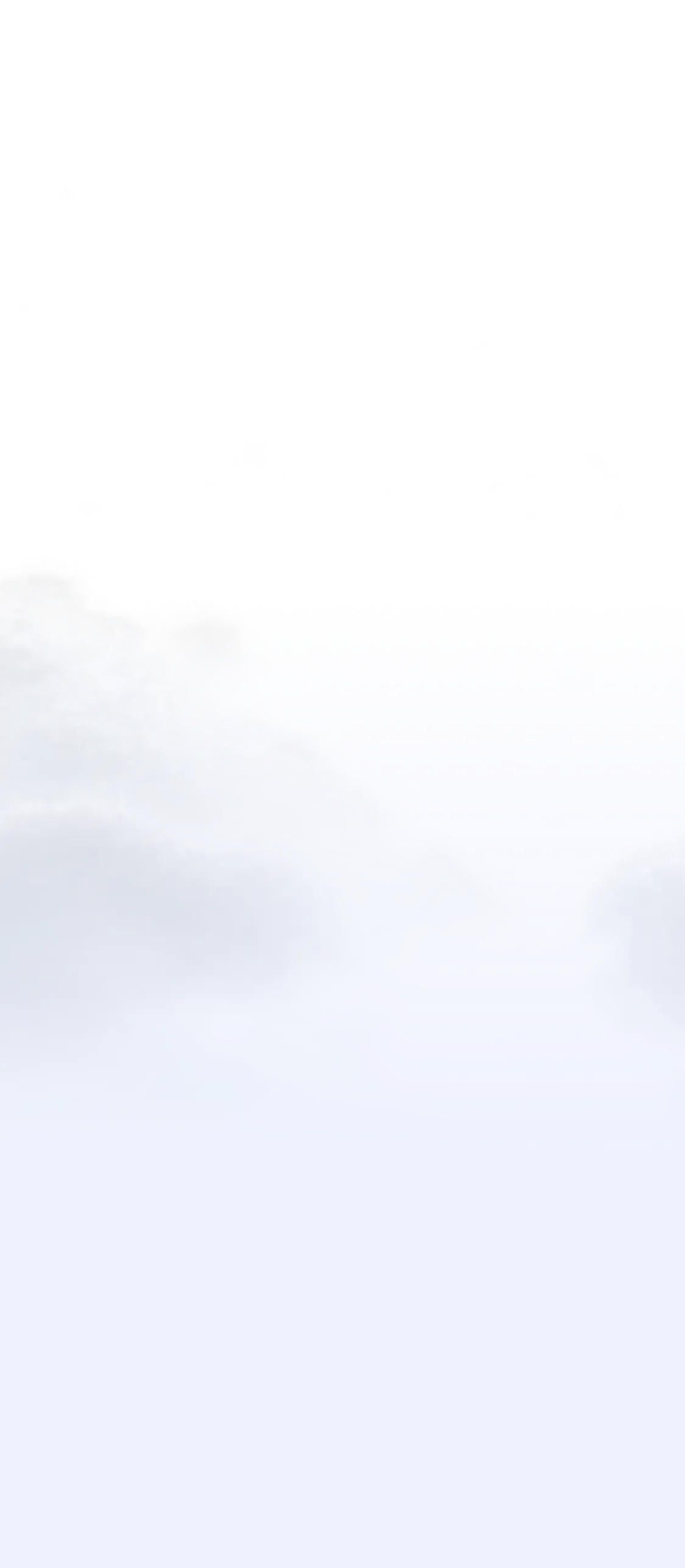 Snow-covered mountain peaks under a partly cloudy blue sky with sunlight illuminating the rocks.