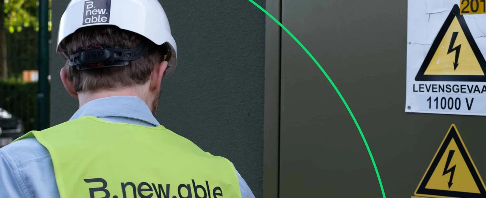 Een Bnewable-technicus met veiligheidshelm en fluohesje opent een hoogspanningscabine met waarschuwingsborden 'Levensgevaar 11 000 V'
