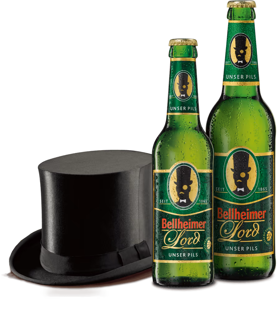 Zwei grüne Bierflaschen mit Bellheimer Lord Etikett neben einem schwarzen Zylinderhut.