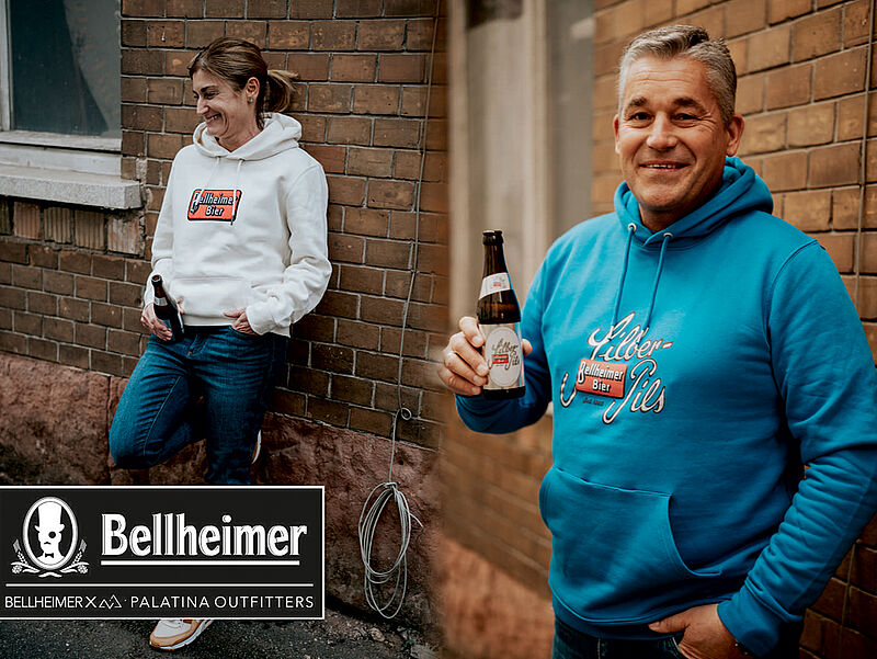 Frau und Mann in Bellheimer Hoodies von Palatina Outfitters vor einer Backsteinwand
