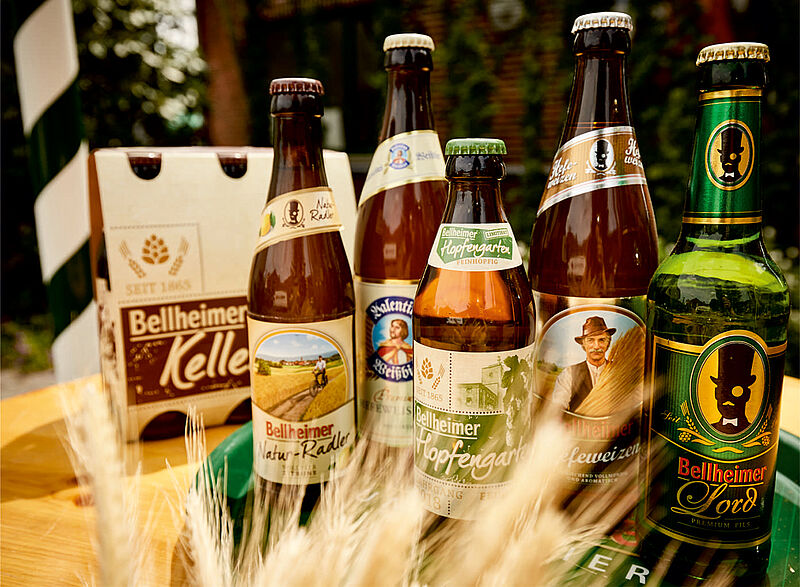 Verschiedene Flaschen Bellheimer Bier, darunter Kellerbier und Lord Pils, mit Getreideähren