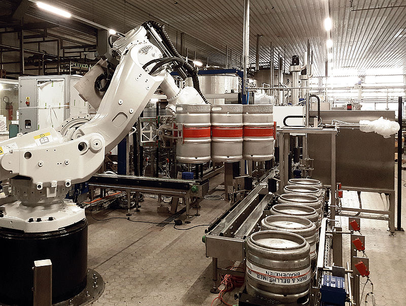 Roboter setzt Bierfässer in der neuen Fassabfüllung der Bellheimer Brauerei auf das Band