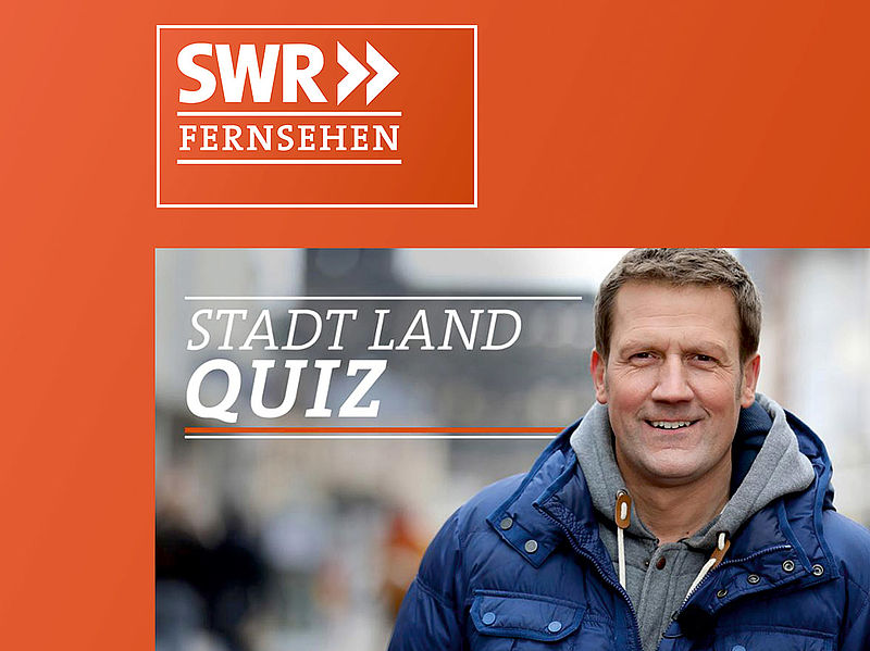 Moderator der SWR-Sendung Stadt Land Quiz vor dem SWR-Fernsehen-Logo