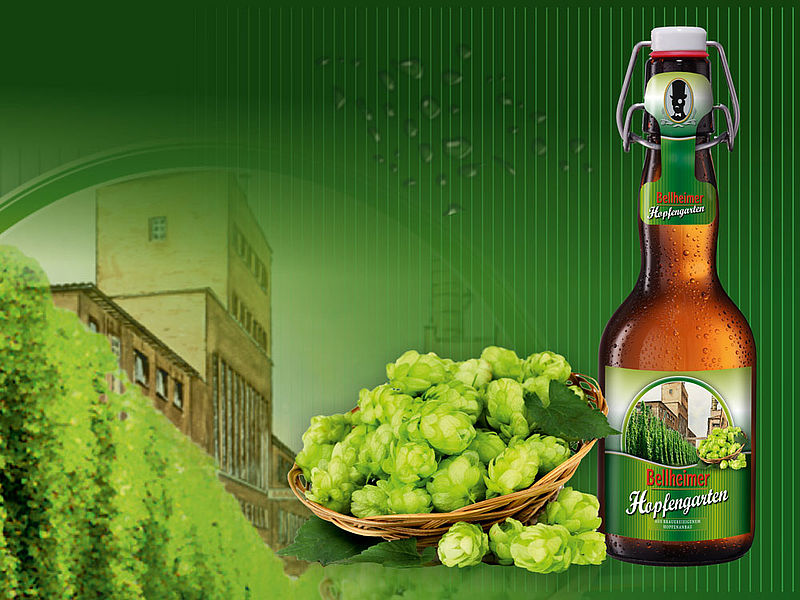 Bügelflasche Bellheimer Hopfengarten mit Korb voller Hopfendolden vor Hopfengarten und Brauerei