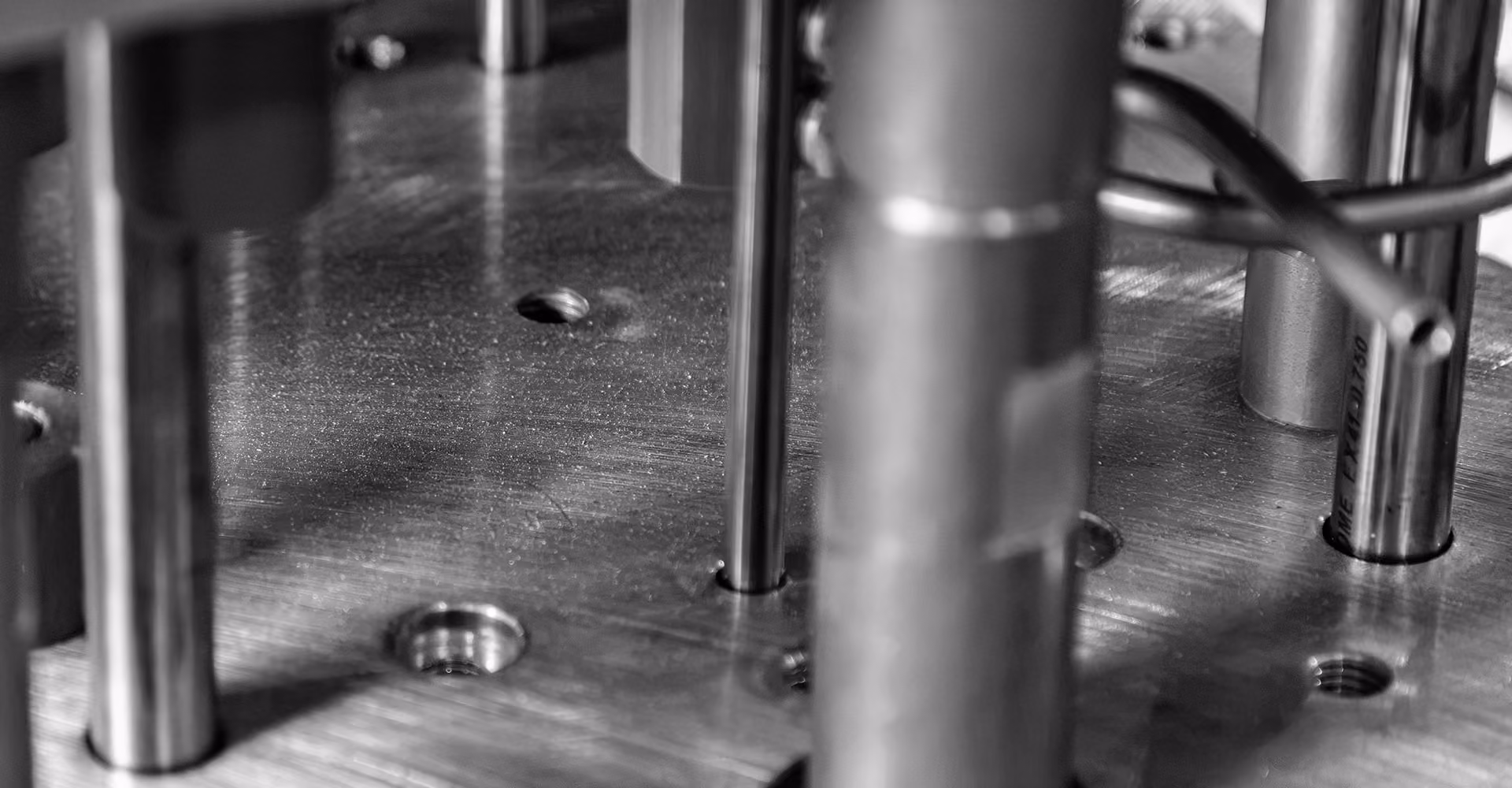 Close-up of a precision-machined custom fixture with steel locating pins and alignment components.