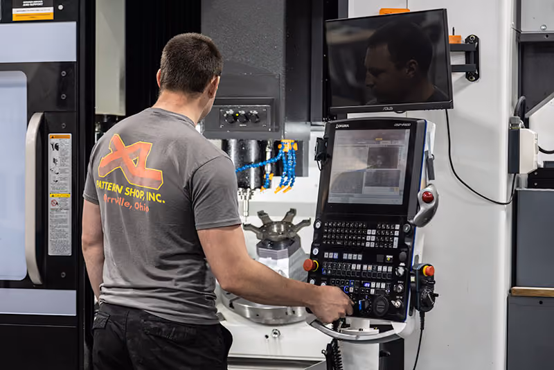 XL Pattern Shop operator setting up a component on a 5-axis CNC machining center.