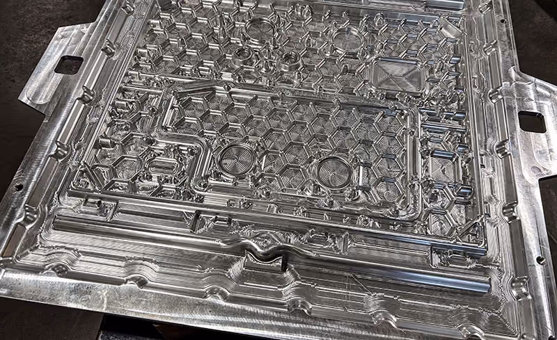 Large, complex aluminum component precision machined with intricate contours, pockets, and detailed geometry.