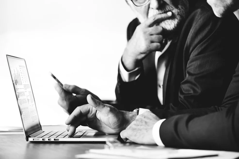 Business professionals reviewing information on a laptop