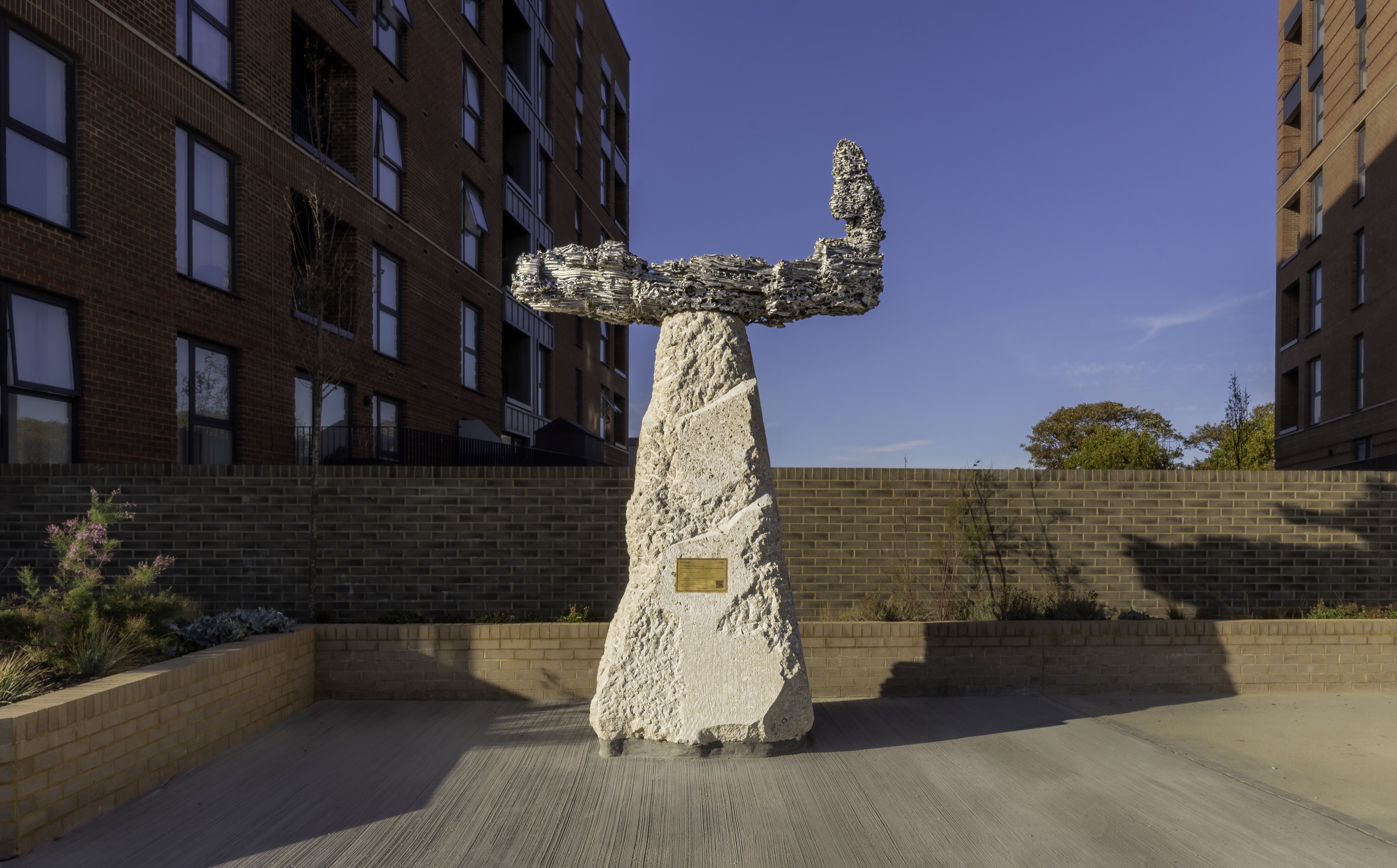 Completed boat-form sculpture and figure on a Portland stone plinth at Kingston Wharf, Shoreham-by-Sea