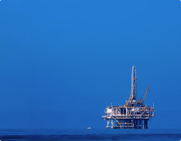 Offshore oil platform illuminated against a deep blue sky