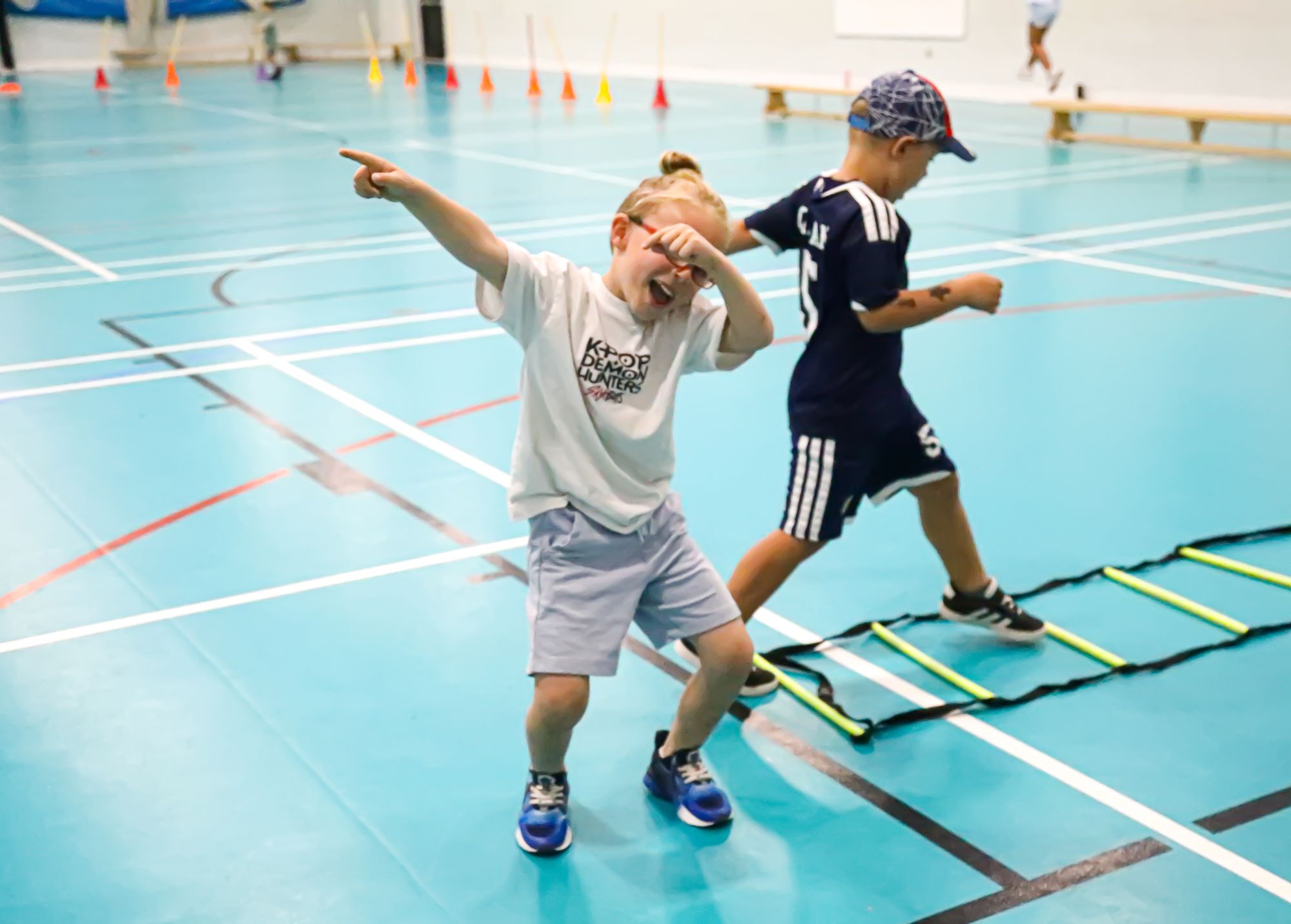 Children practising footwork on an indoor agility ladder
