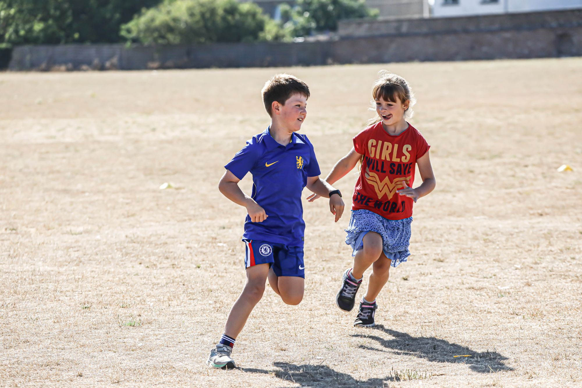 Two children running outdoors at Sports Bug