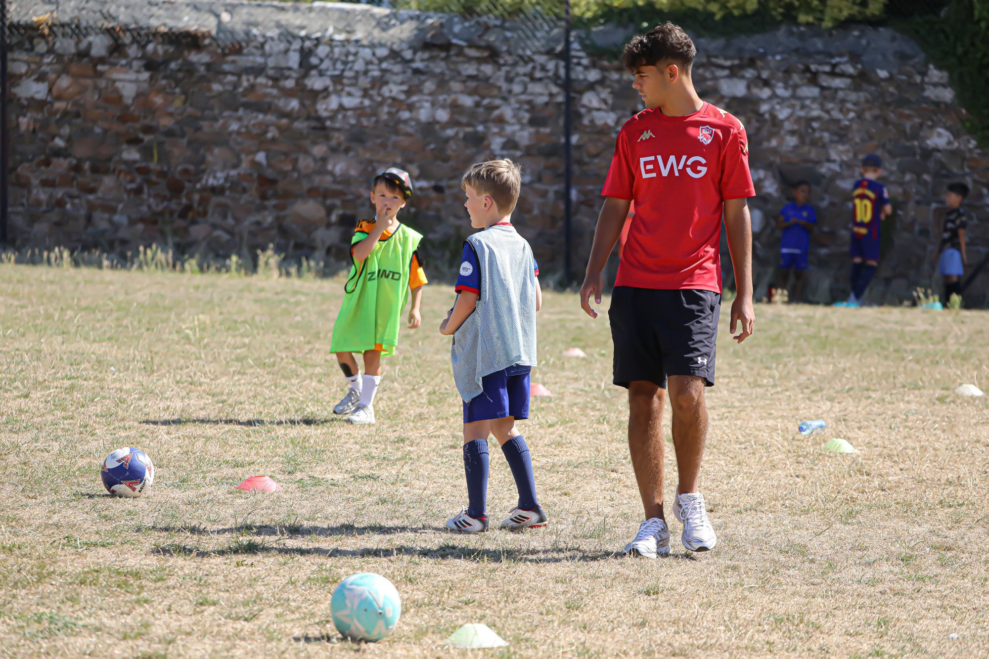 A Jersey Bulls coach with children on the pitch at a Sports Bug session