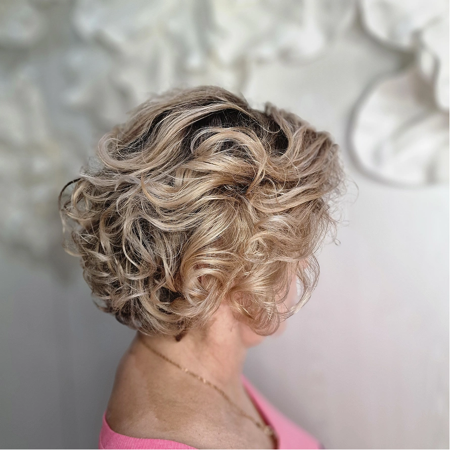 Nahaufnahme einer Friseurin, die langes Haar mit einer Schere schneidet.