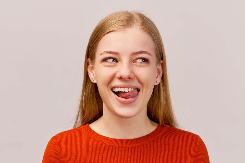 A young woman is smiling and making a funny face.