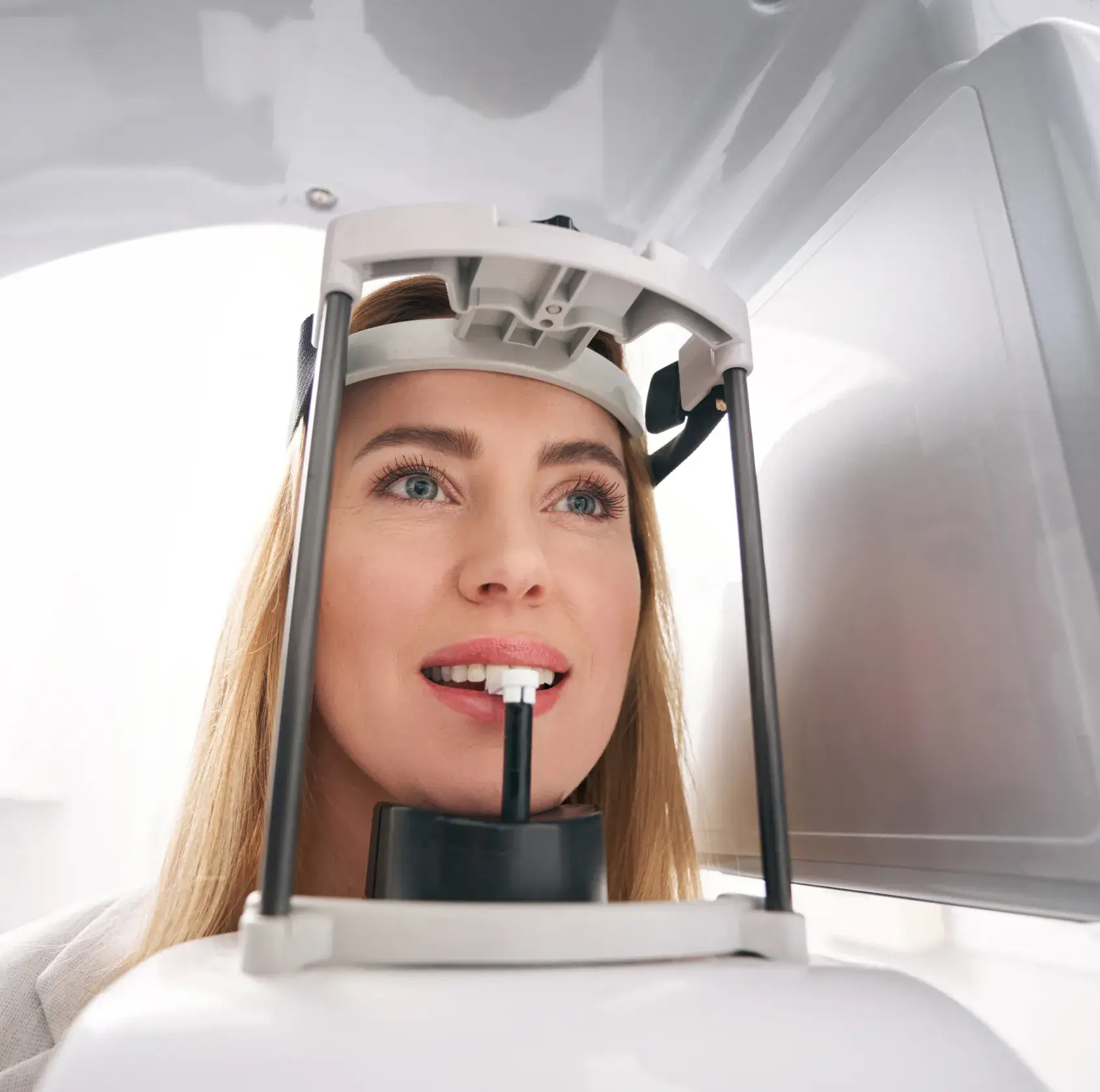 A woman is looking through a microscope at something.