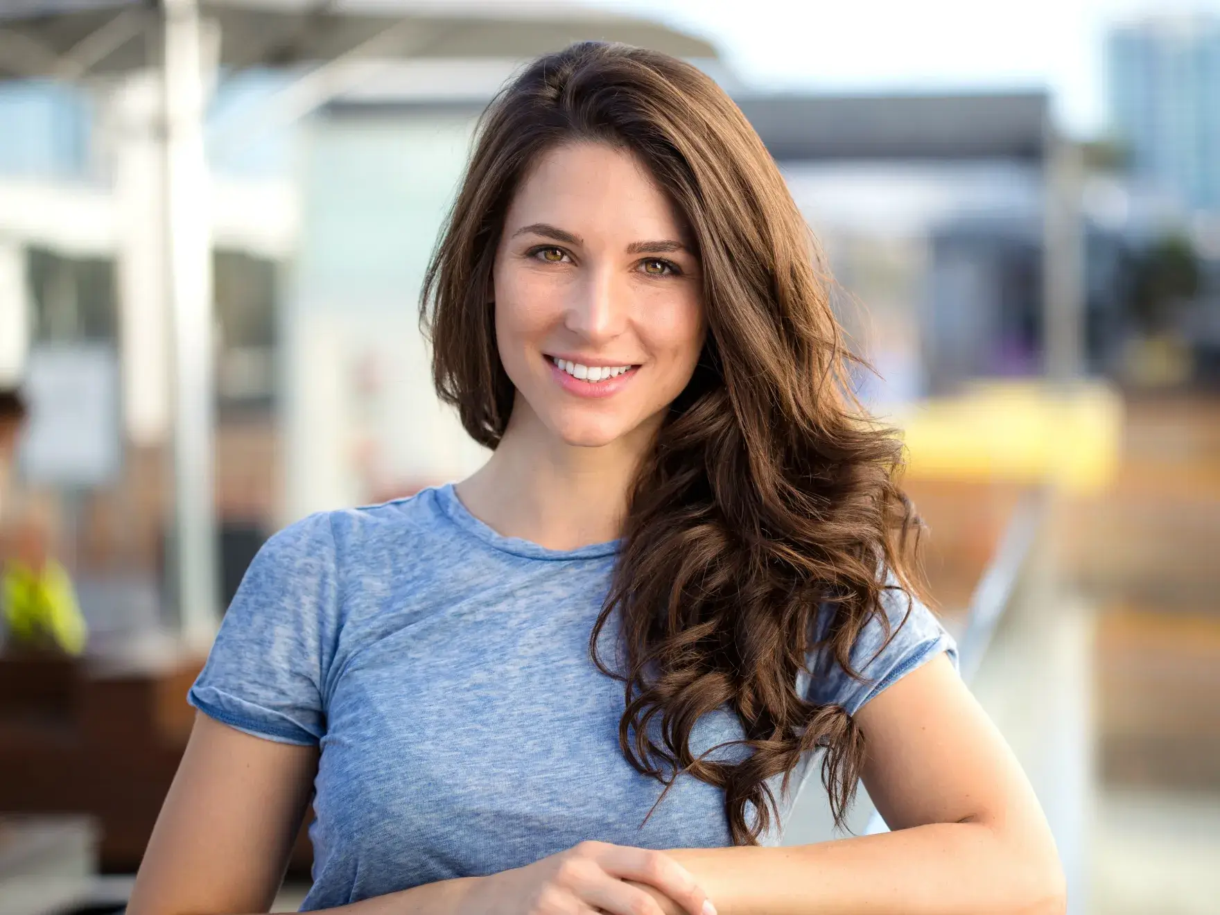 A woman with long brown hair and a blue shirt.