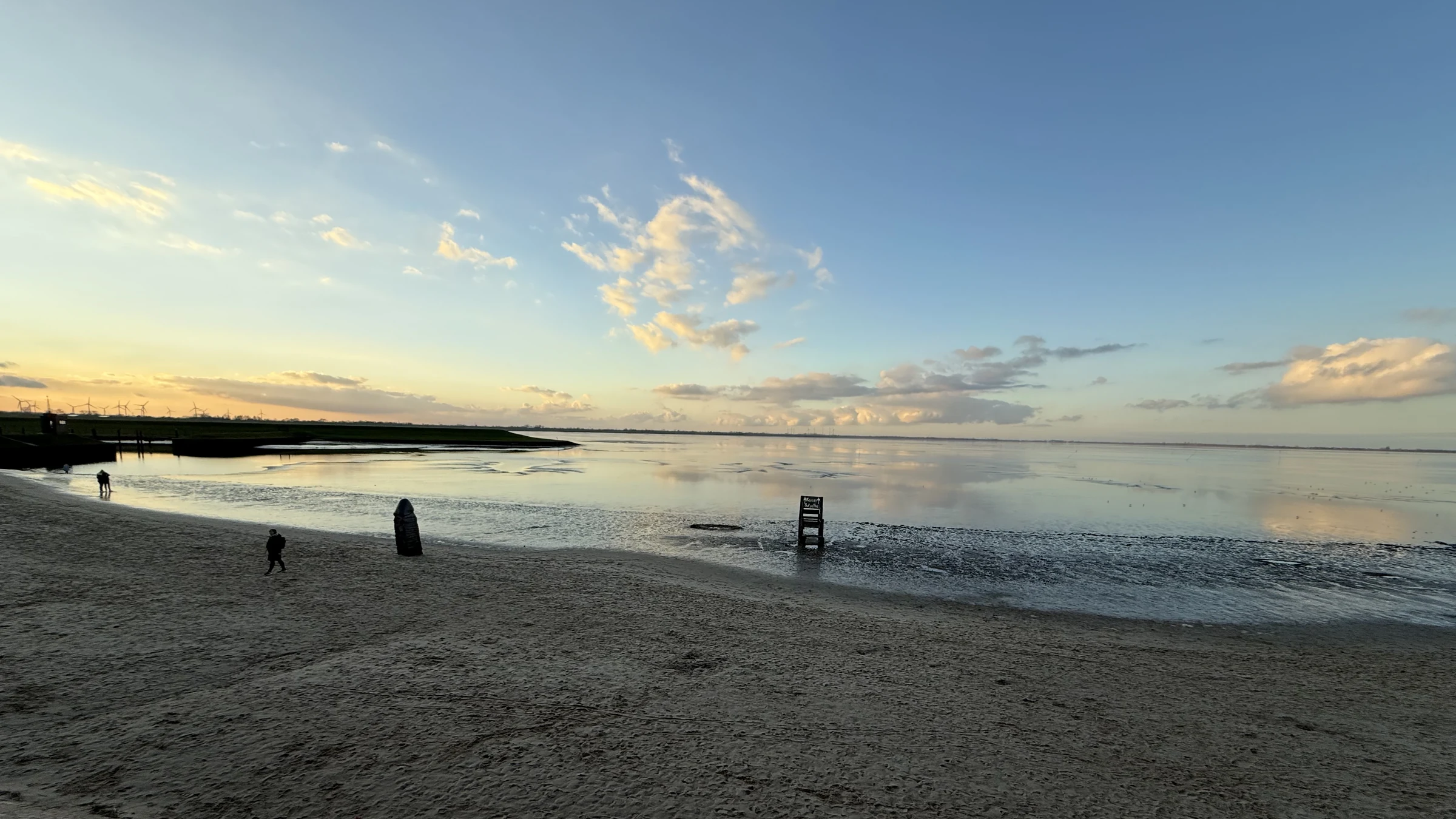 Abendlicht über dem Watt am Jadebusen bei Dangast, Deichlinie am Horizont