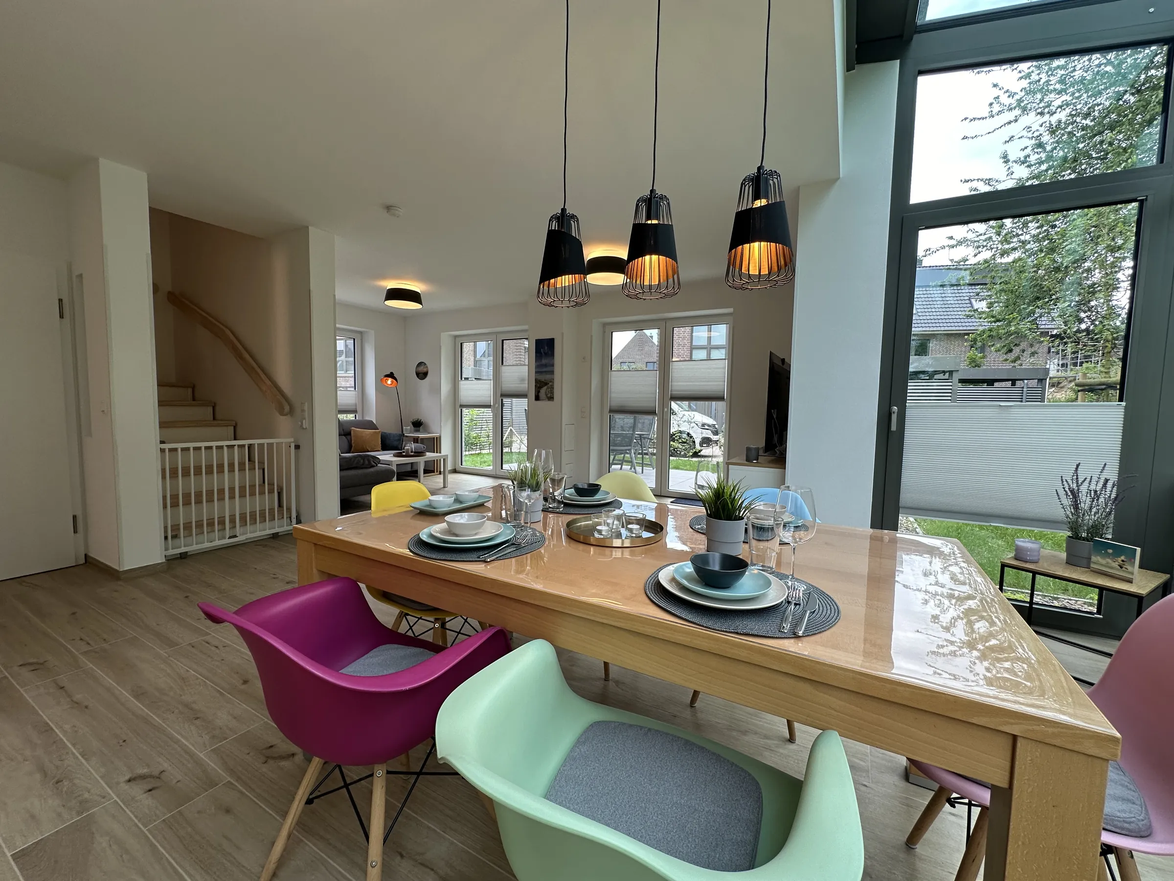 Essplatz im offenen Wohnraum des DAN53-Ferienhauses mit Blick in den Garten