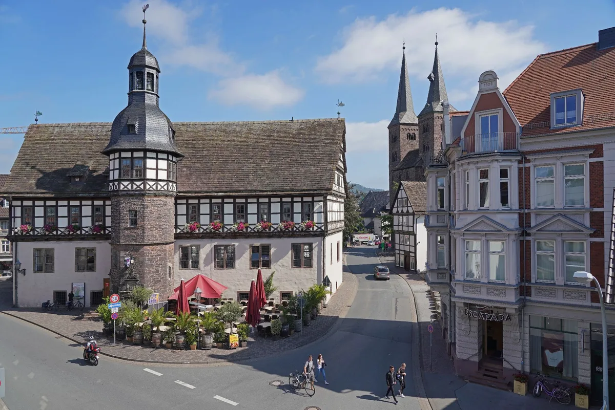 Blick über den Platz auf das Historische Rathaus mit Fachwerkobergeschoss und Turmhaube, dahinter die Türme der Kilianikirche in Höxter