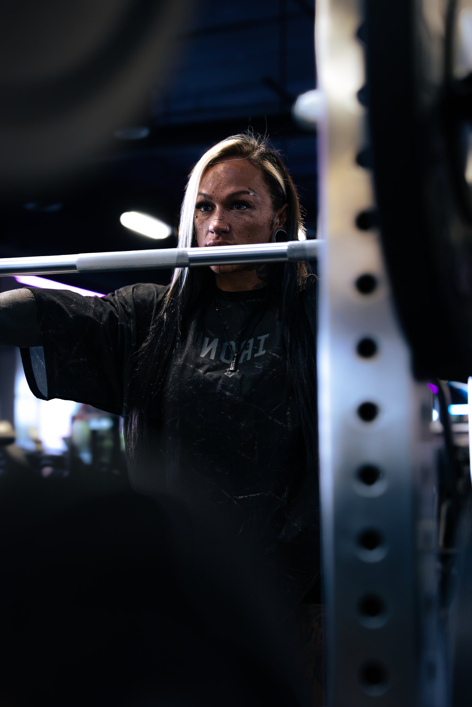 Jordain Sue looking past the barbell in the squat rack