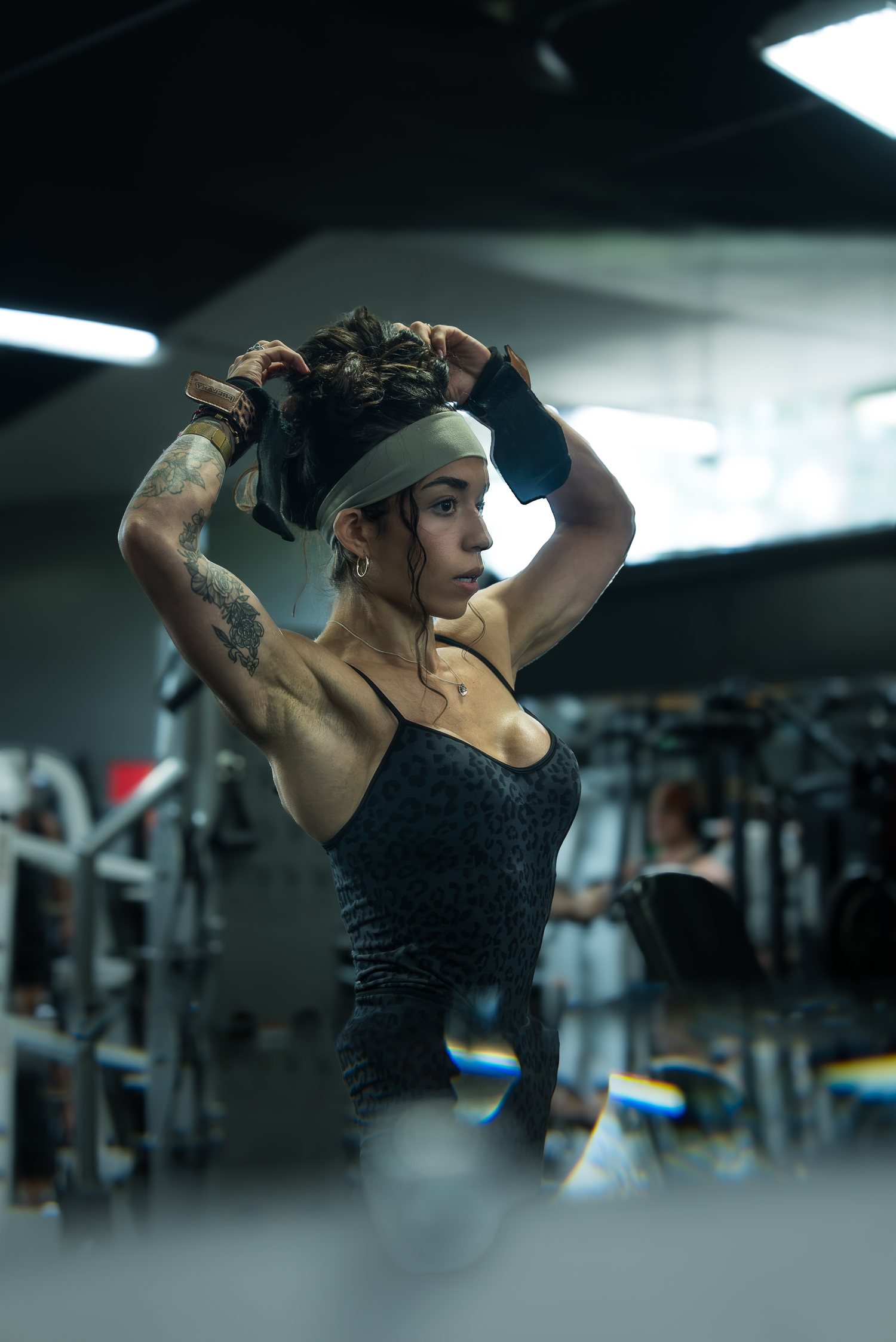 Roxy Cisneros fixing her headband with both hands behind her head