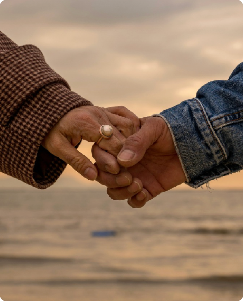 Two people holding hands at sunset