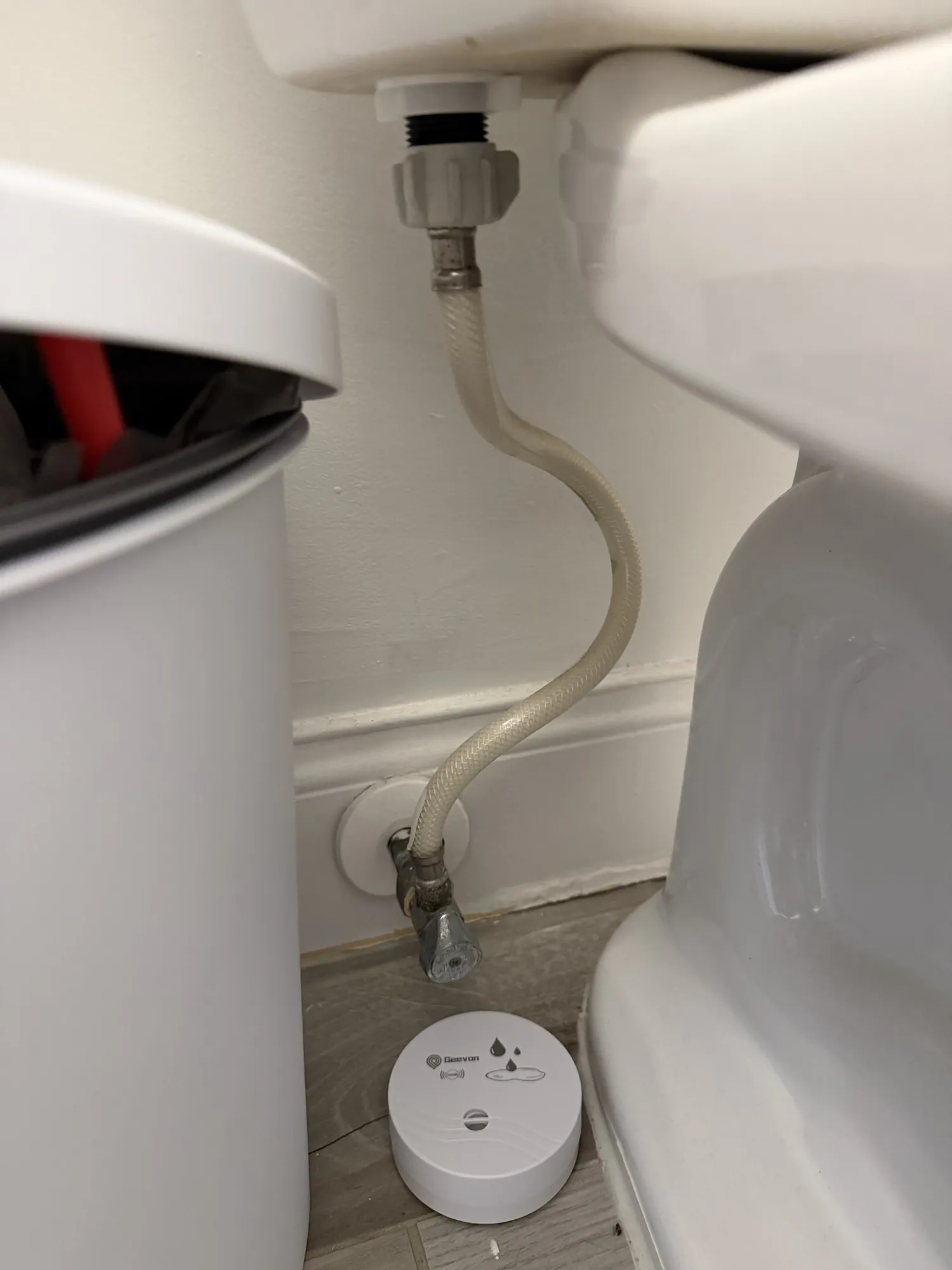 Water leak sensor on the floor behind a toilet supply line in a South Florida bathroom