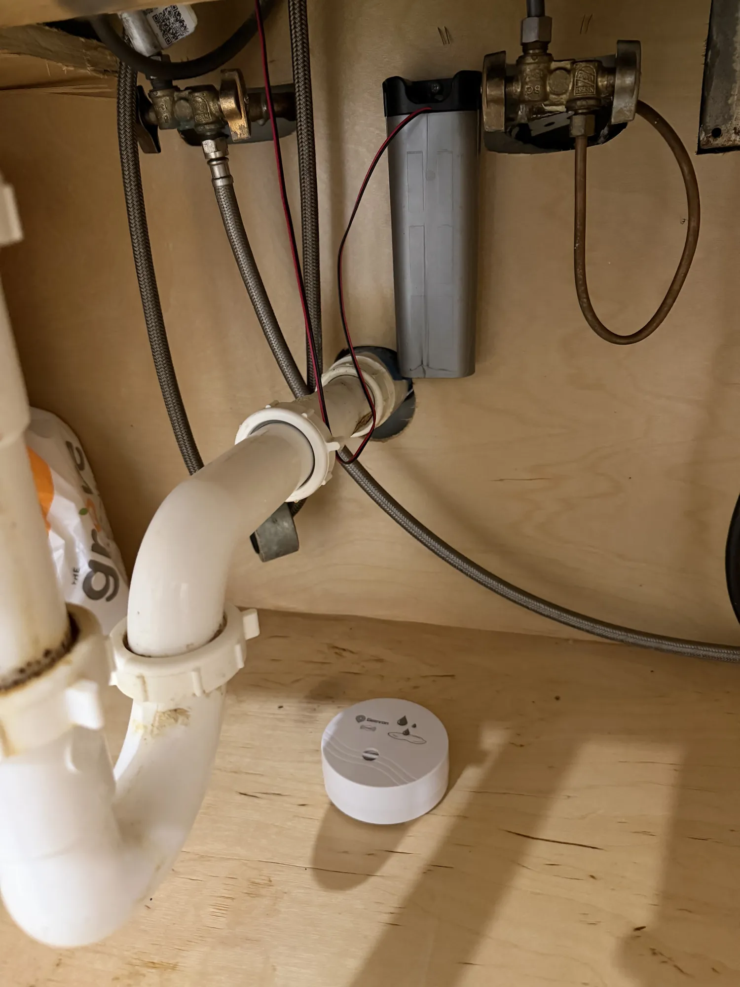Smart water leak sensor placed under a kitchen sink near supply lines in South Florida