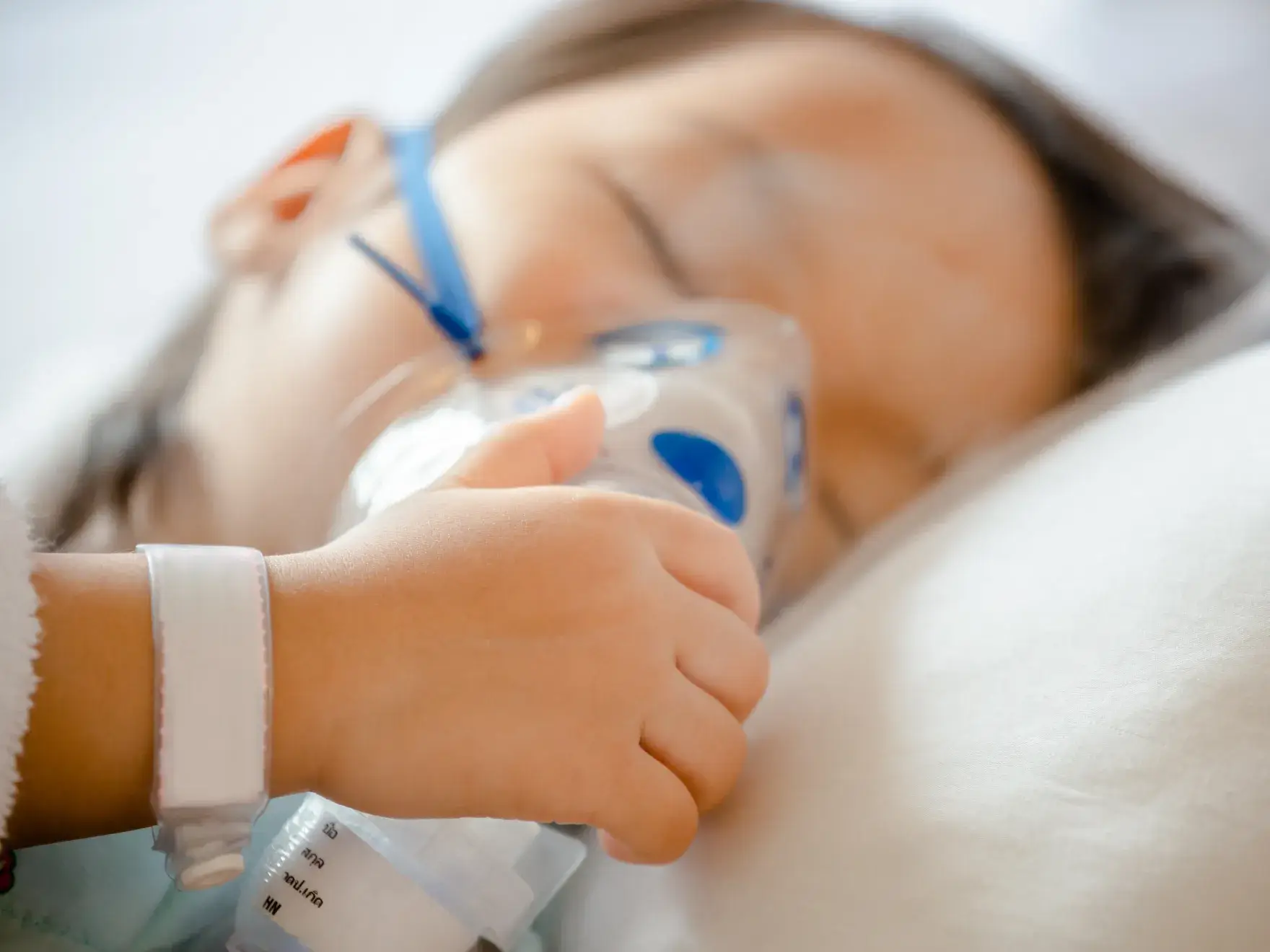 a little girl laying in bed with a thermometer in her hand