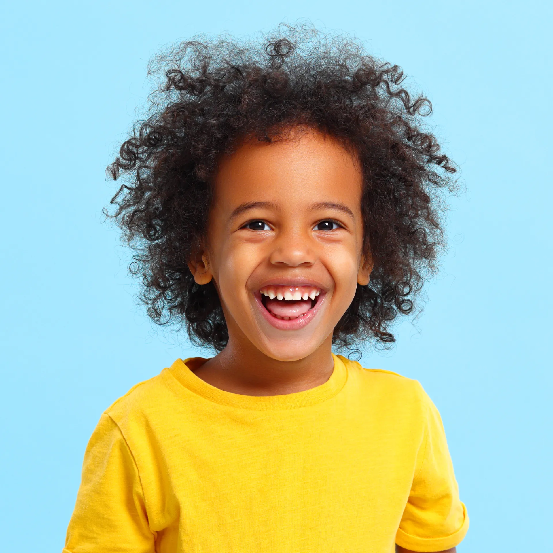 a little girl smiling with a toothbrush in her mouth