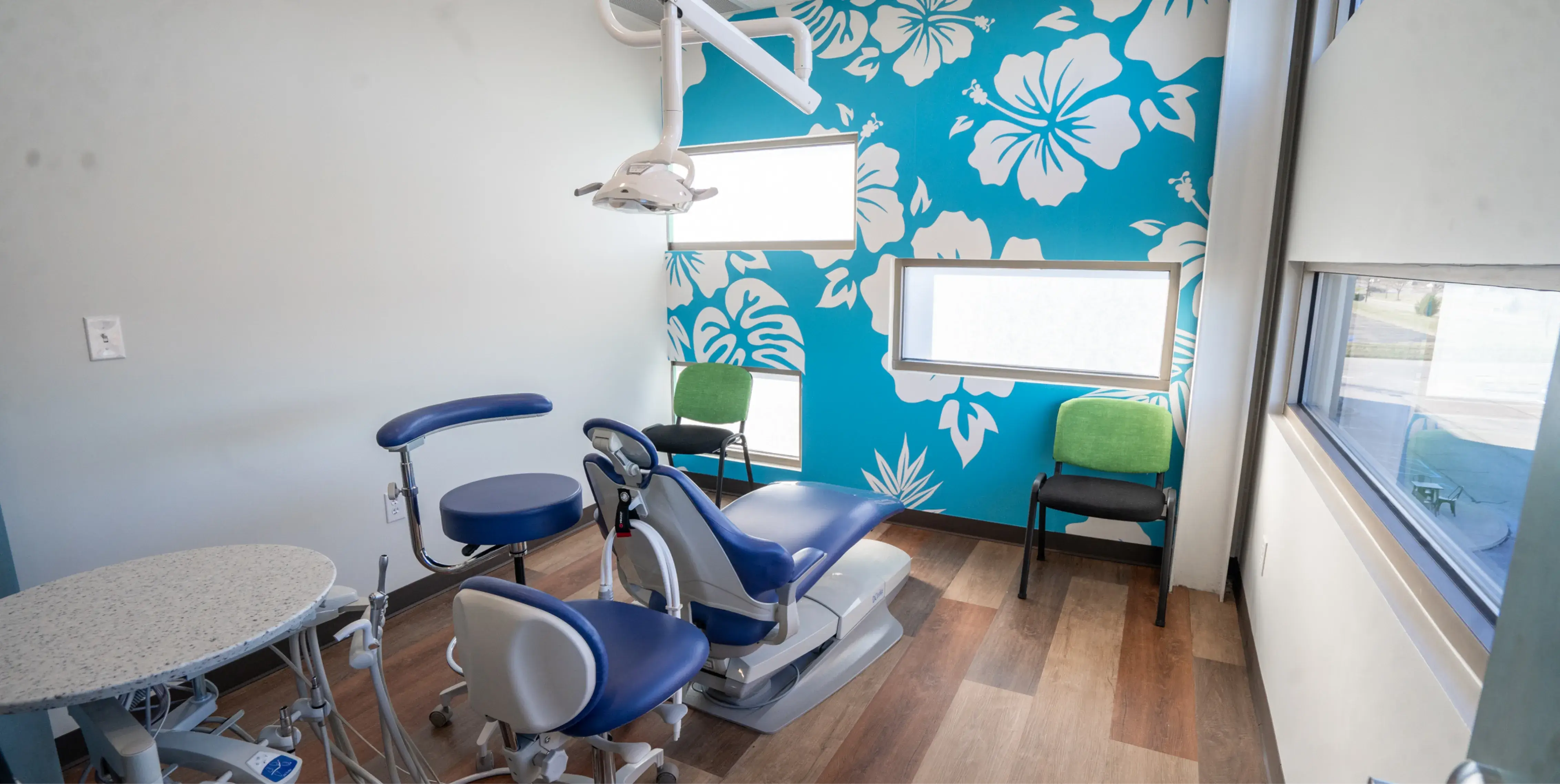 A dental room with a blue flower wallpaper.