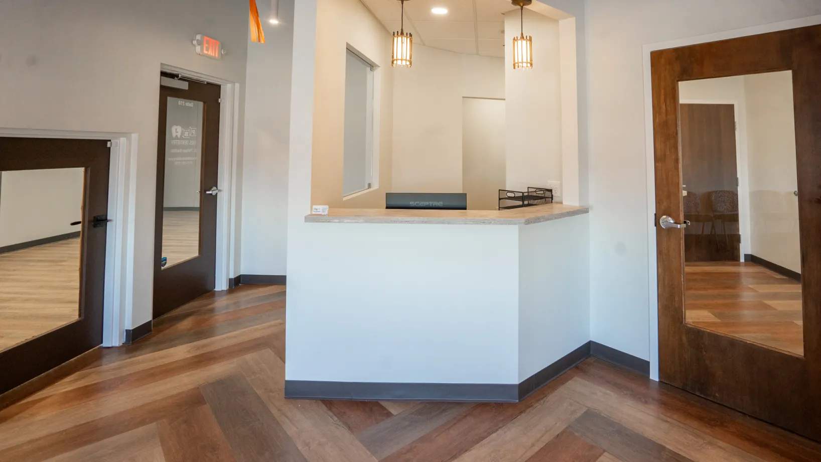 An empty room with a counter and two doors.