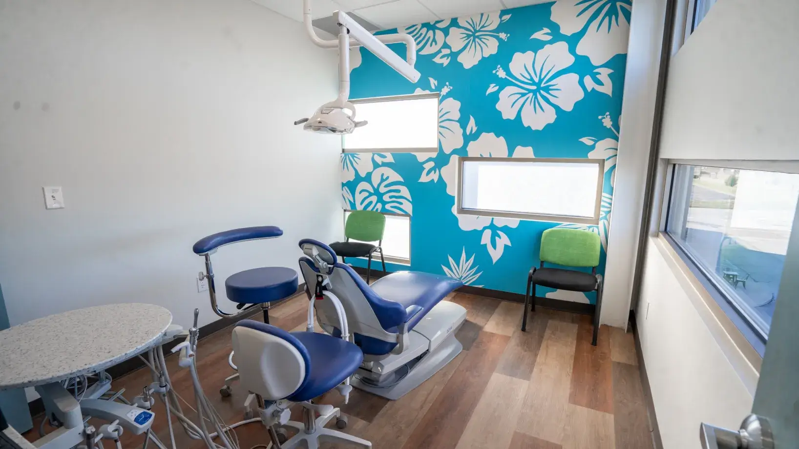 A dentist's chair in front of a floral wallpaper.